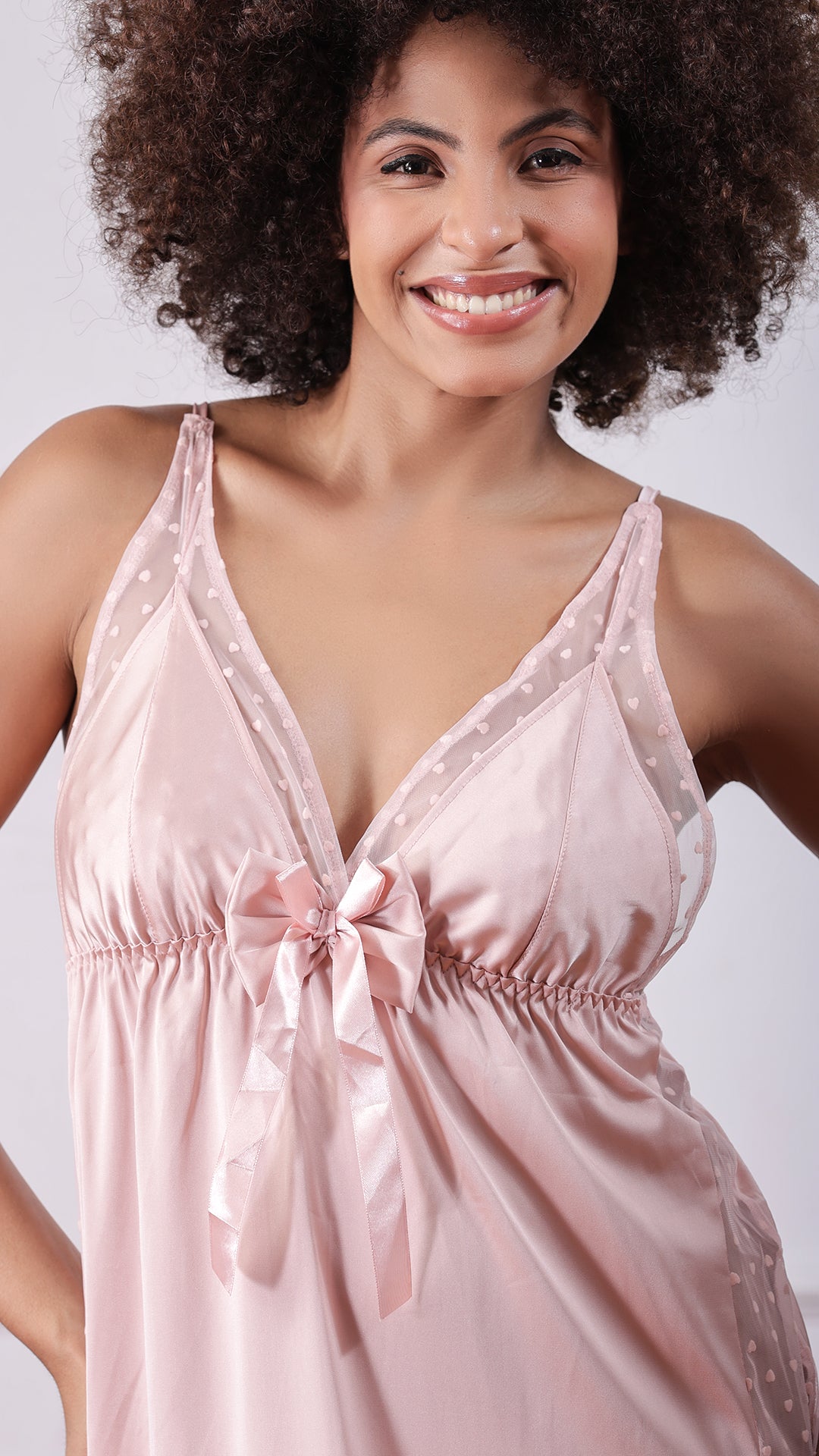 Close-up of blush pink satin nightdress with bow detail and heart mesh panel