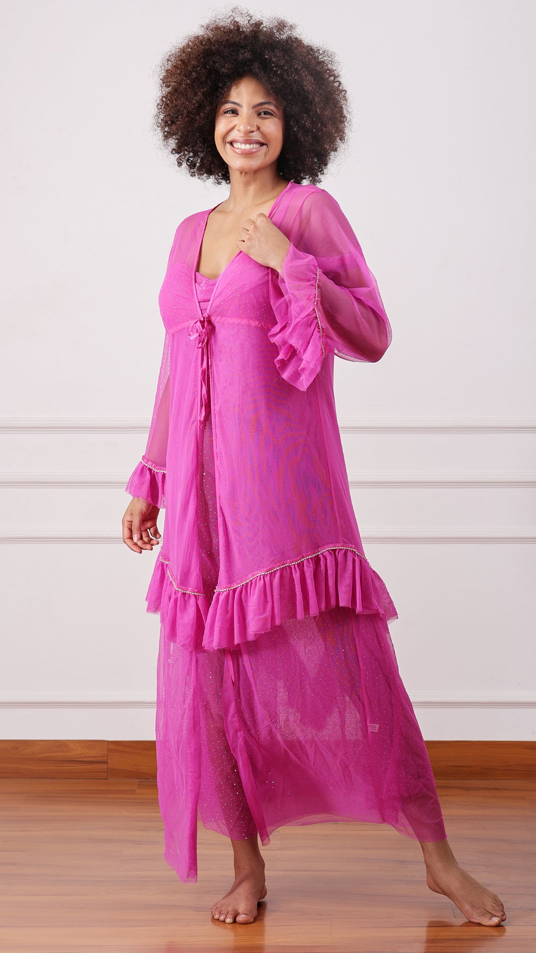 Woman wearing a sheer pink mesh cami dress, cold-shoulder sleeves