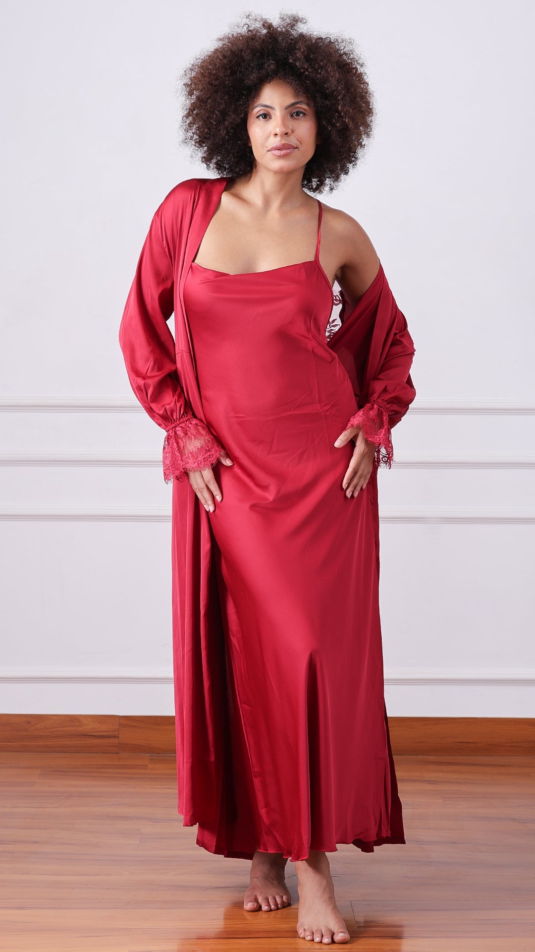 Woman wearing maroon satin nightgown with matching lace-cuff robe