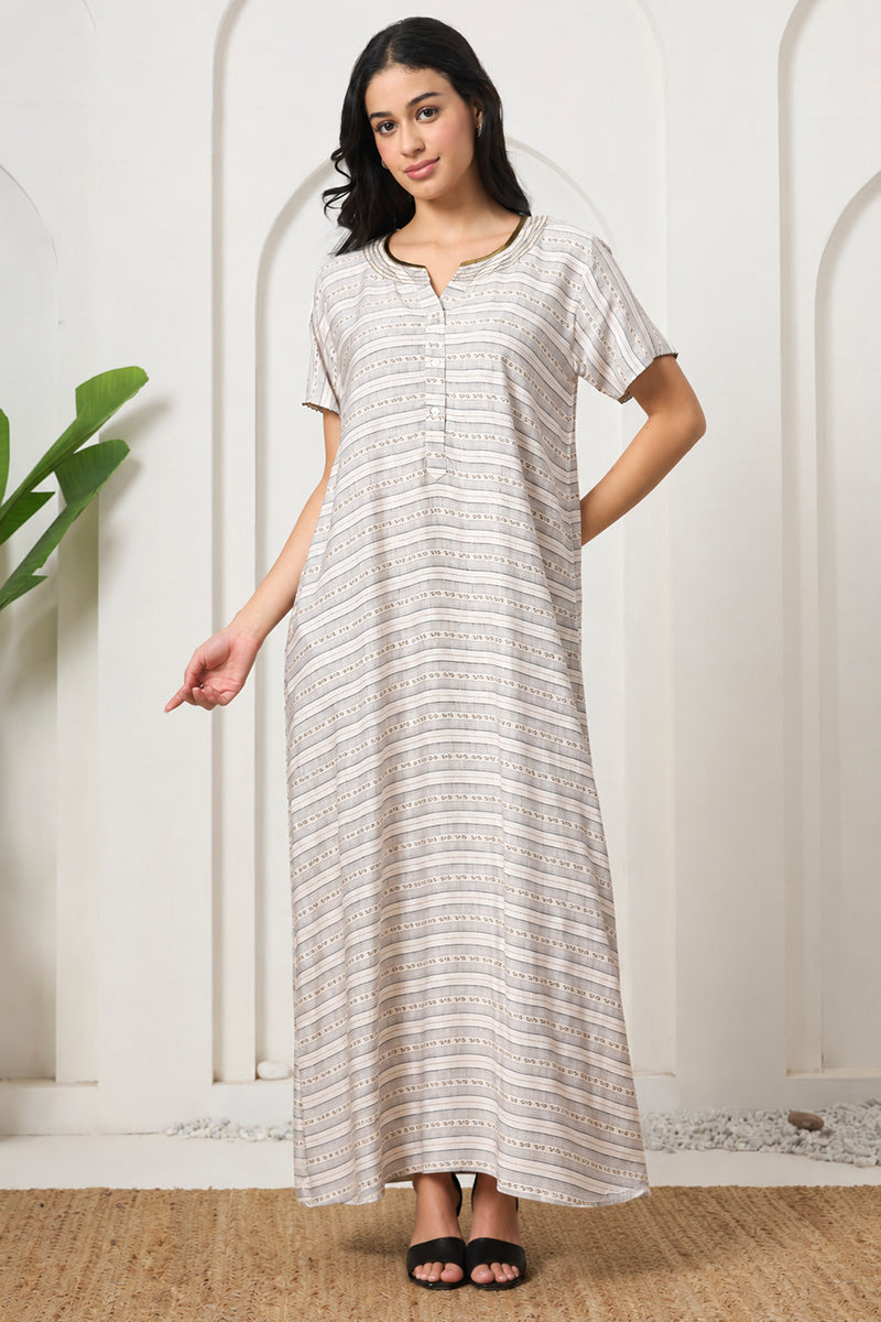 Woman standing with hand pointing, wearing a beige striped nightgown