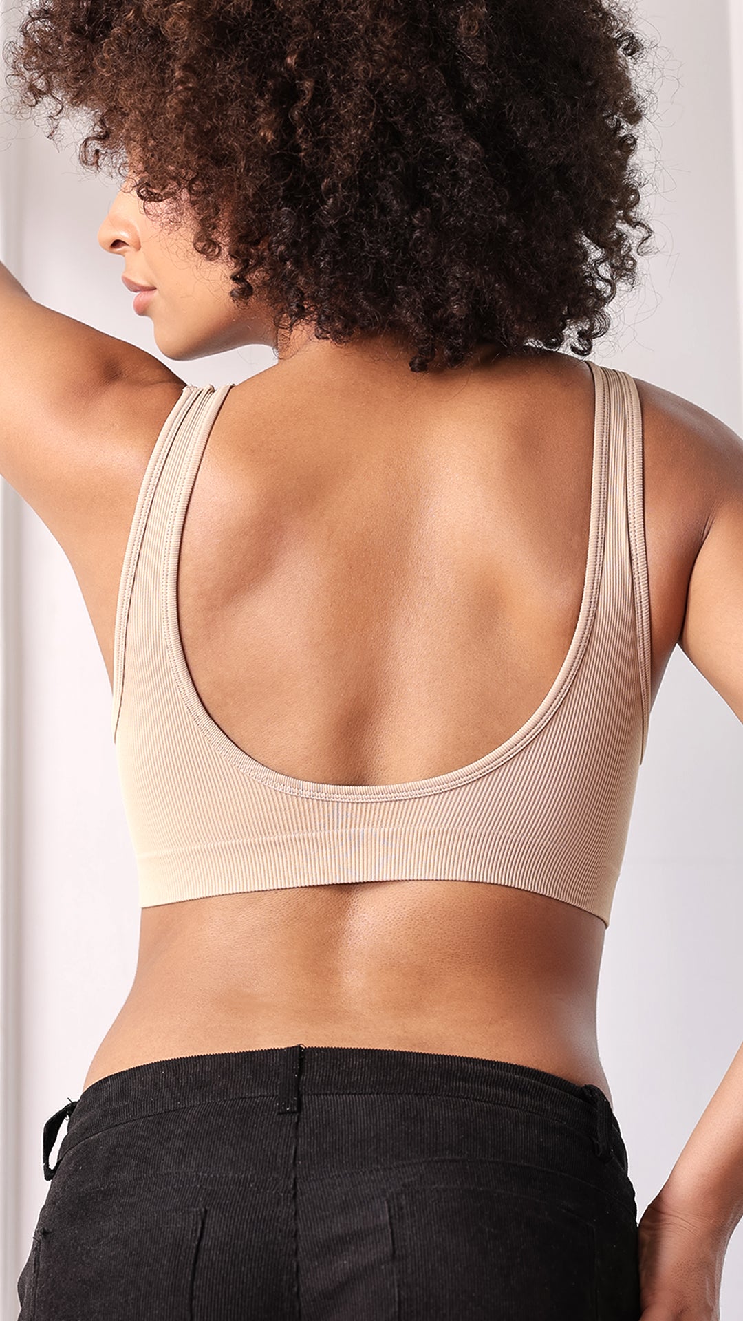 Back view of beige ribbed bra showing deep scoop back and straps