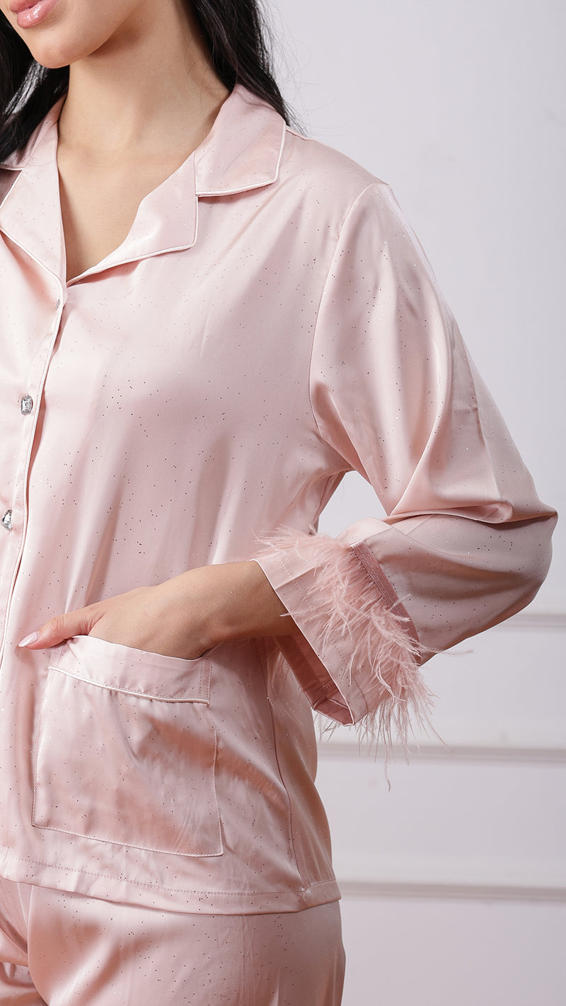 Close-up of blush pink satin pyjama jacket with feather trim sleeve and pocket