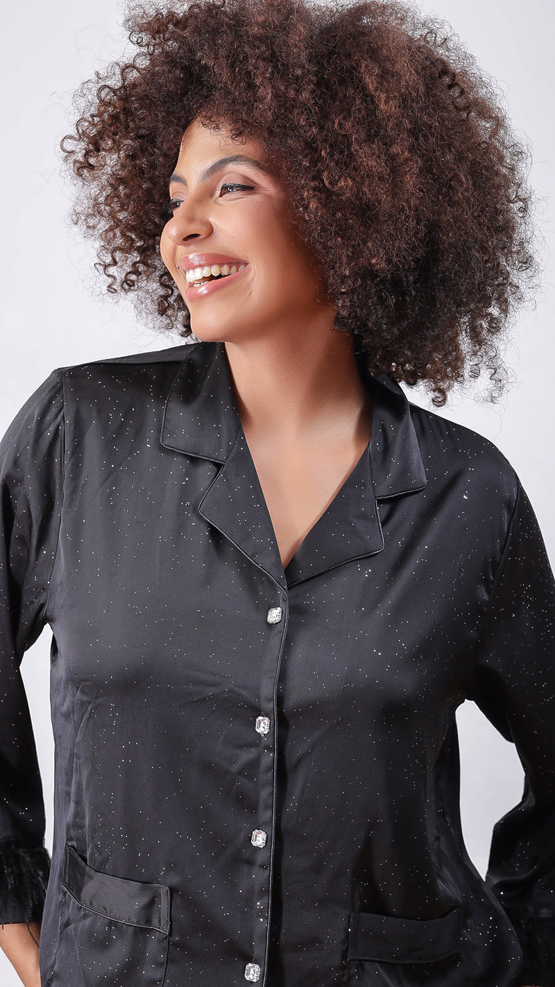 Close-up of woman wearing black glitter satin shirt with crystal buttons
