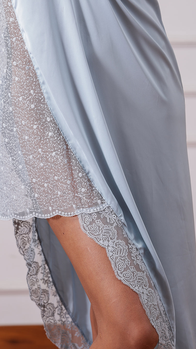 Close-up of pale blue satin nightgown asymmetric lace hem detail