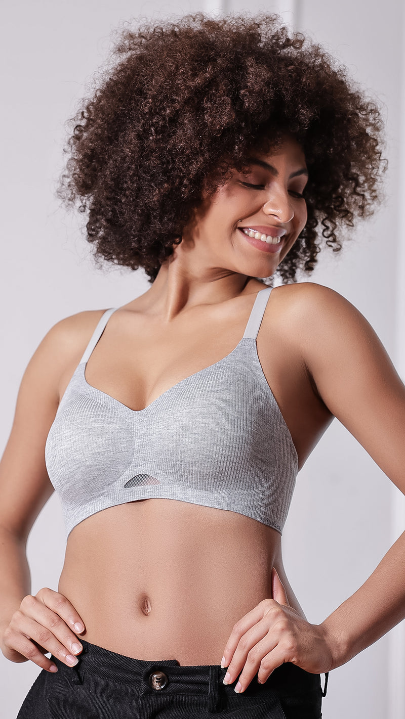 Woman posing in grey wireless full coverage bra with black pants