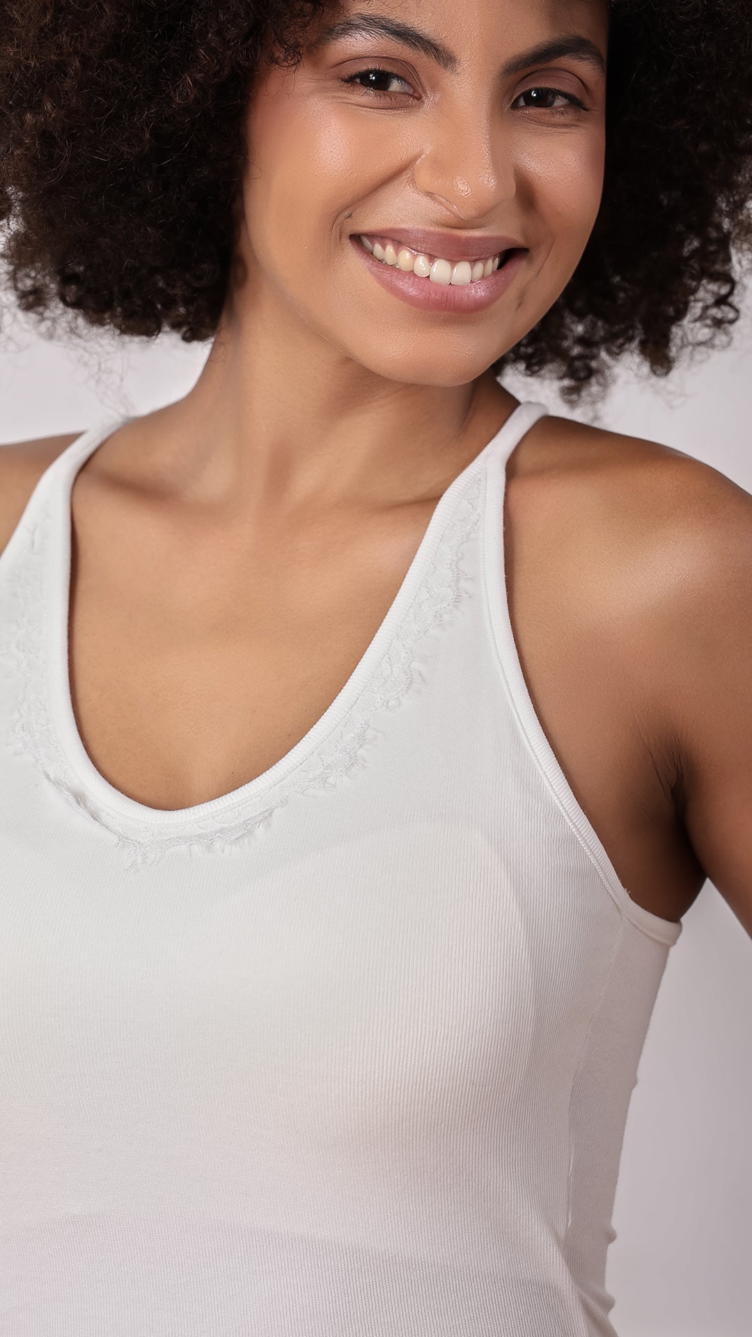 Close-up of lace-trim neckline on white racerback tank top