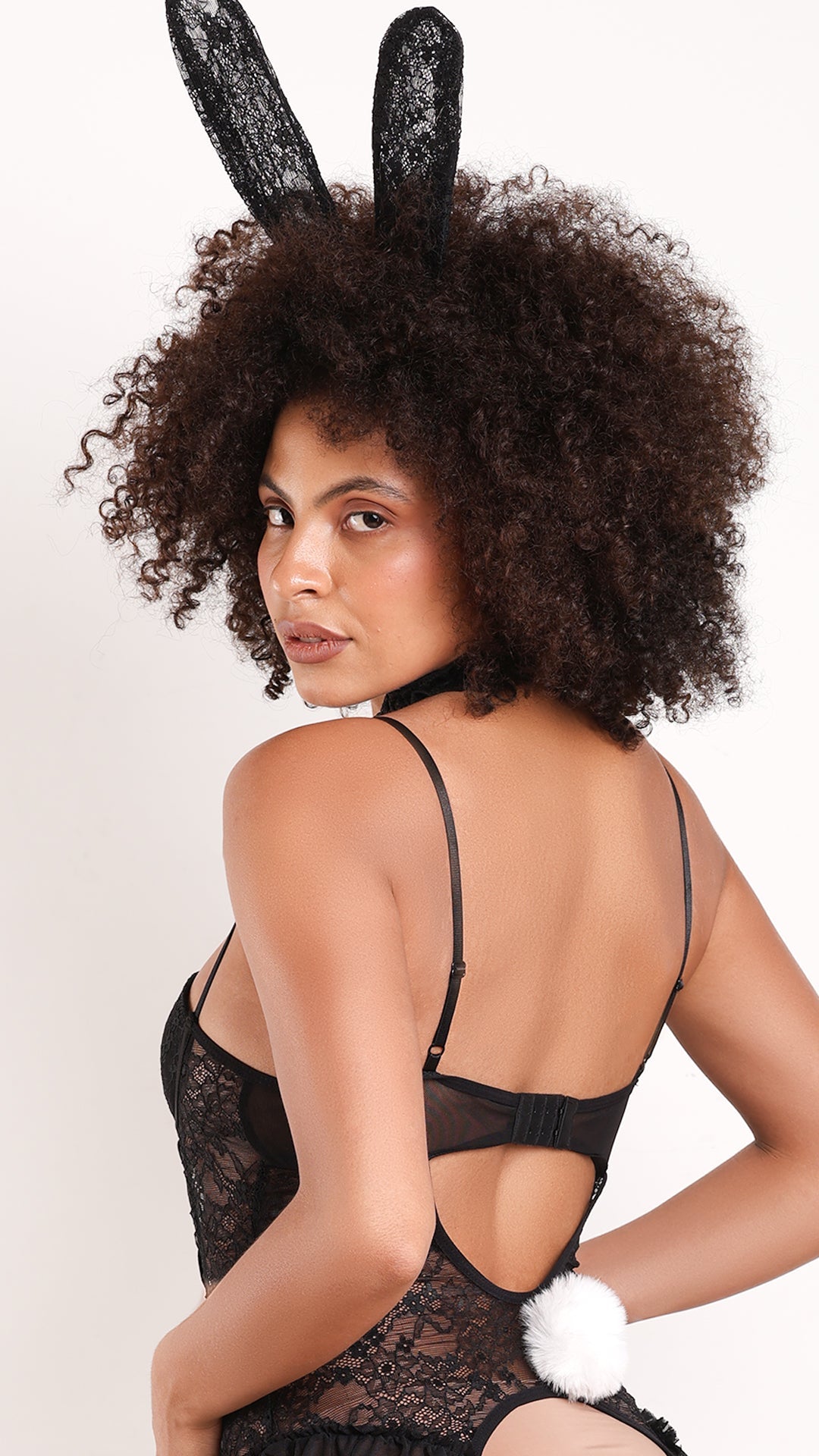 Back view of black bunny costume with open-back lace bodysuit and pom-pom tail