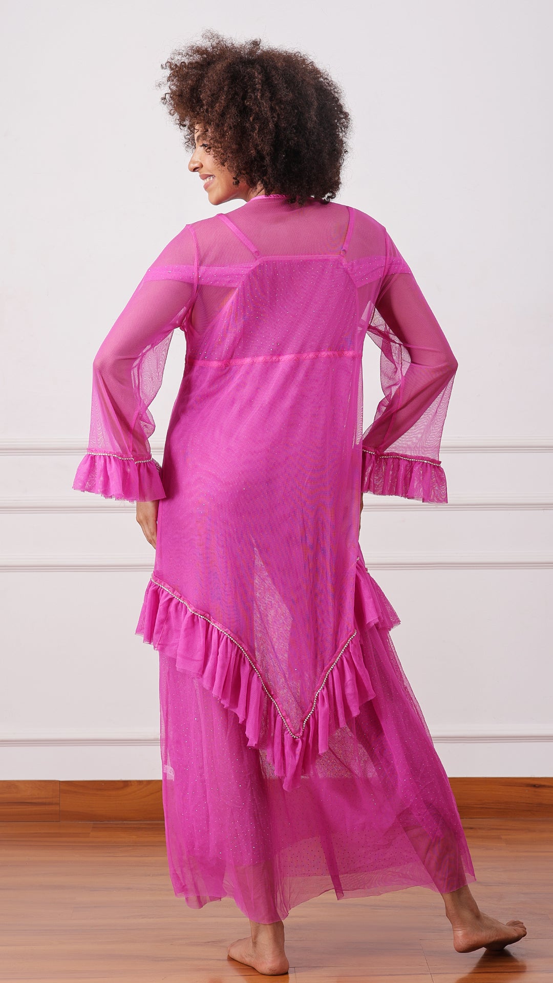 Woman wearing a sheer pink mesh robe with ruffle hem