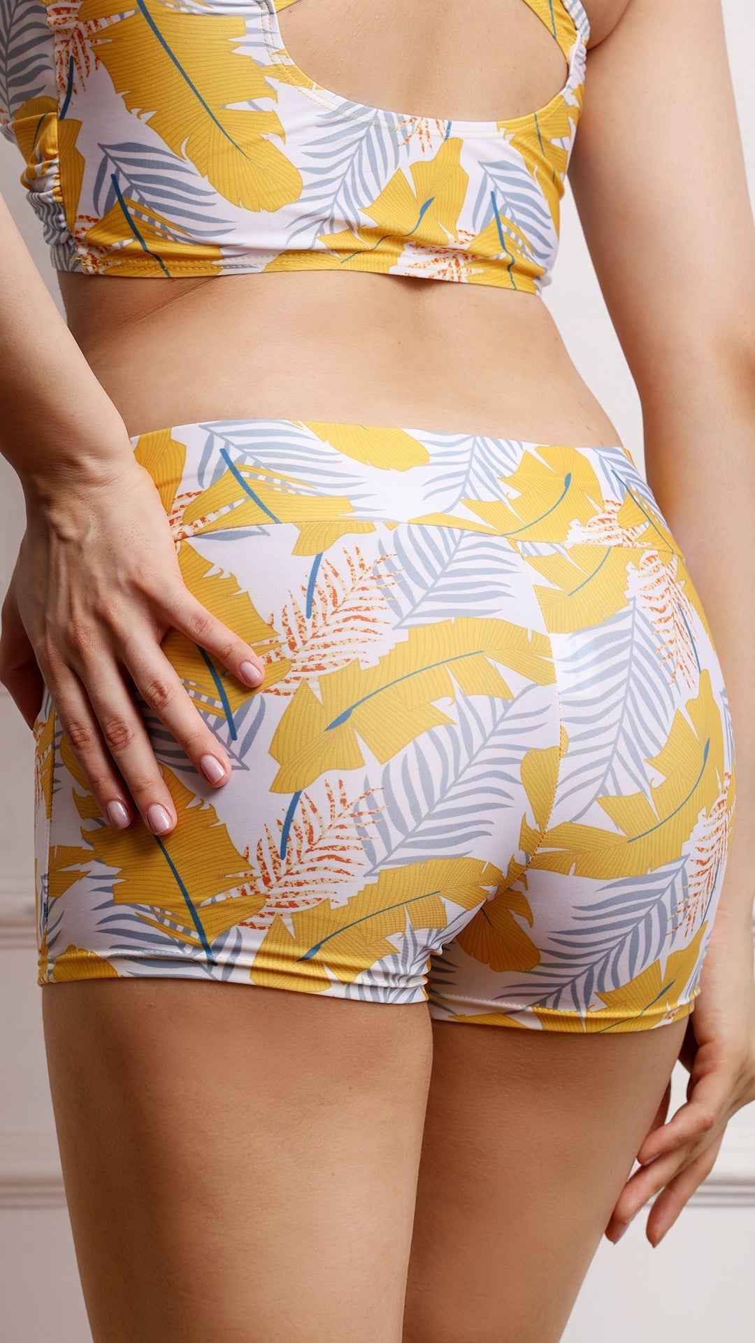 Close-up back view of tropical print shorts on model