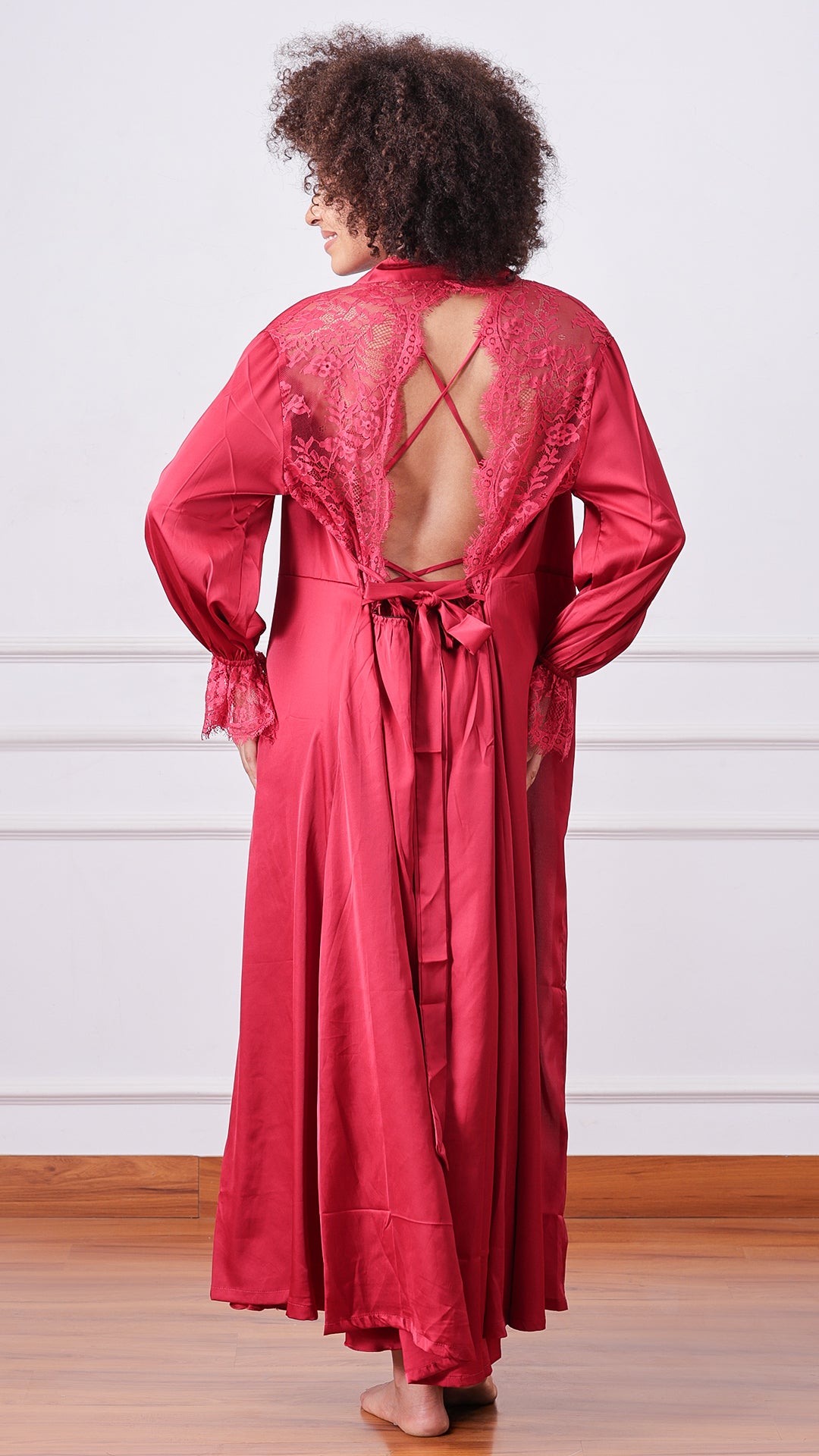 Back view of woman wearing maroon satin robe with lace yoke detail