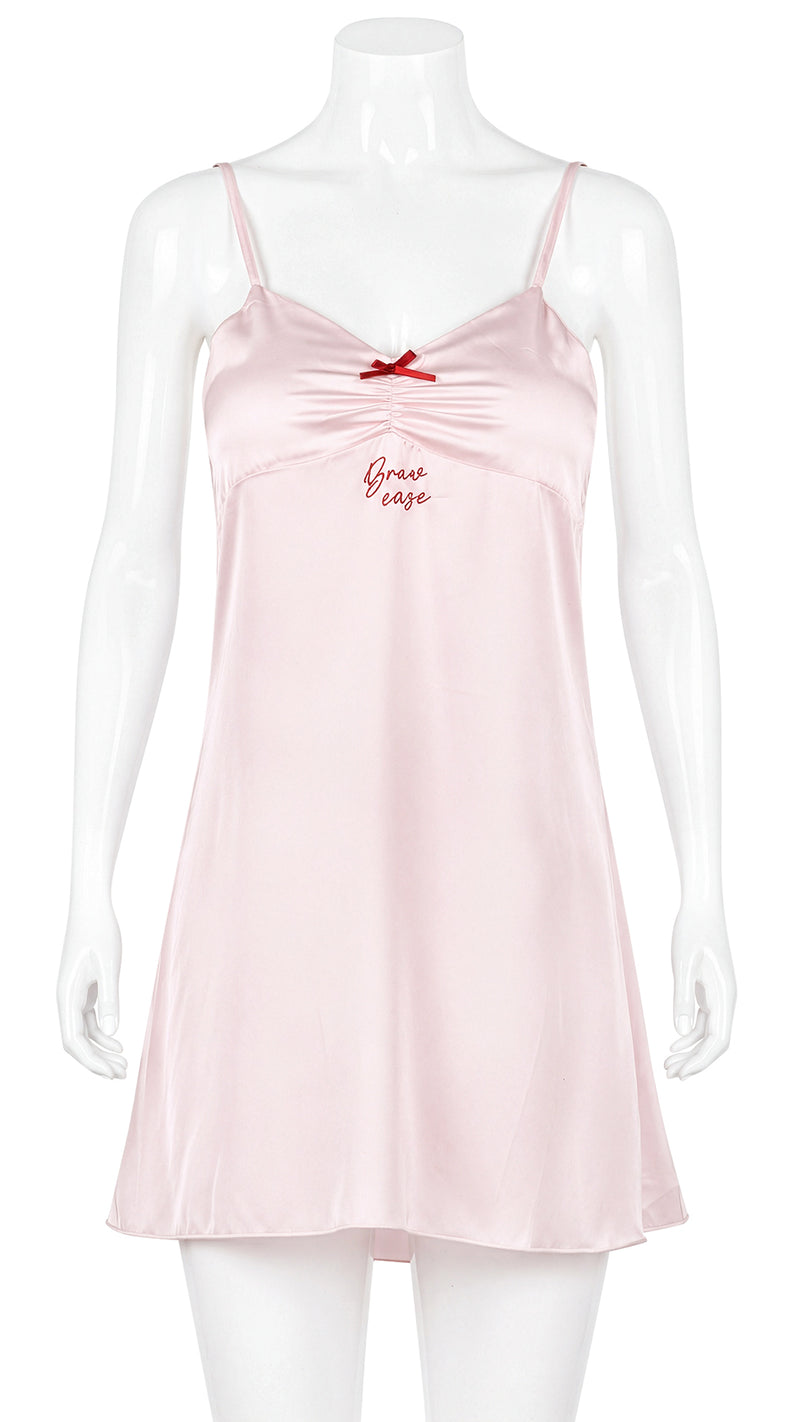 Mannequin display of pink satin chemise with red bow detail