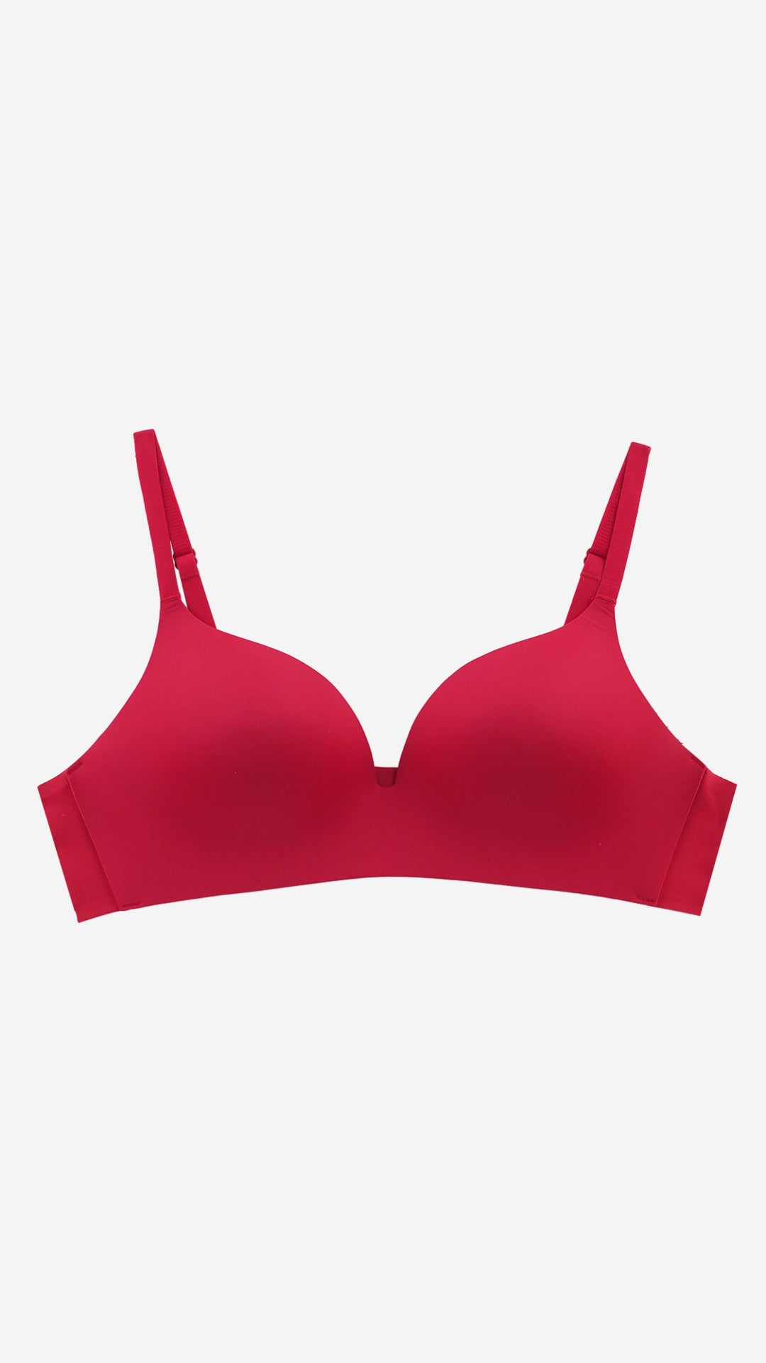 Red seamless push-up T-shirt bra on white background, front flat lay