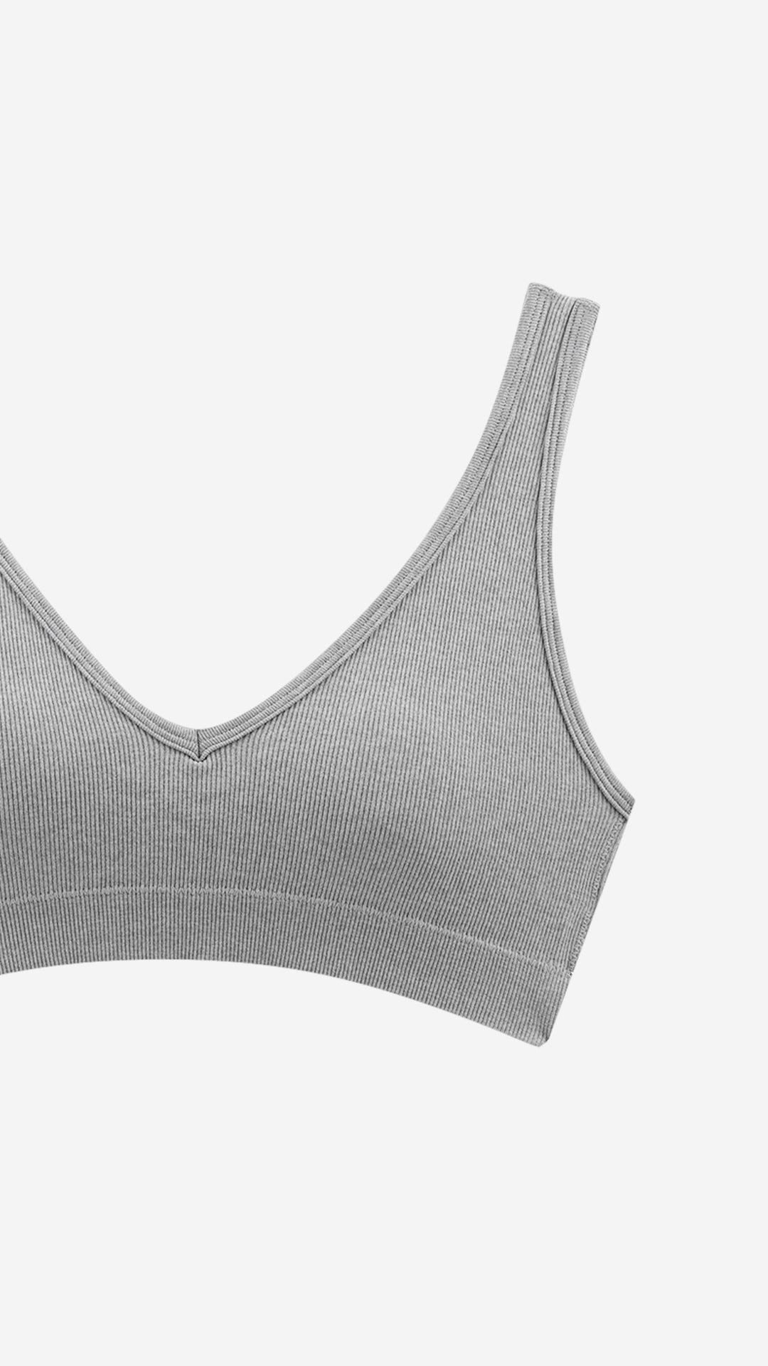Close-up of beige ribbed bra strap and V-neck edge on white background