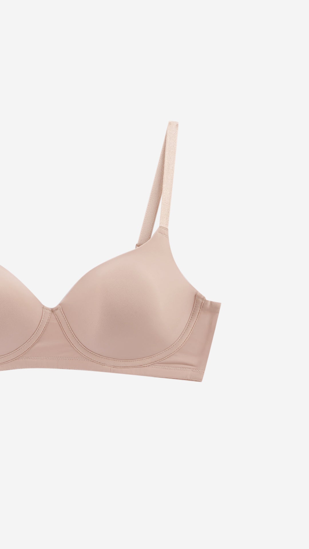 Close-up of beige plunge bra strap and cup edge on white background