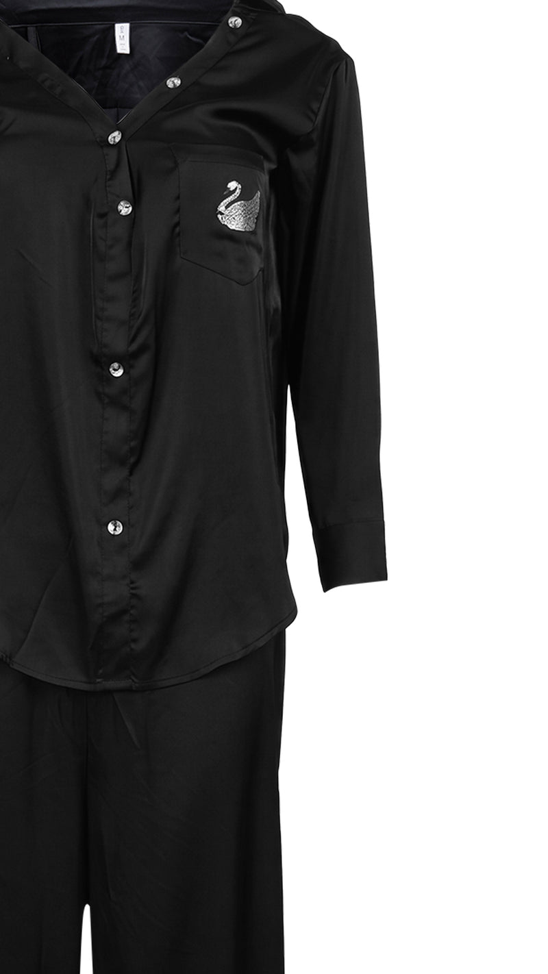 Close-up product shot of black satin pyjama shirt and pocket detail
