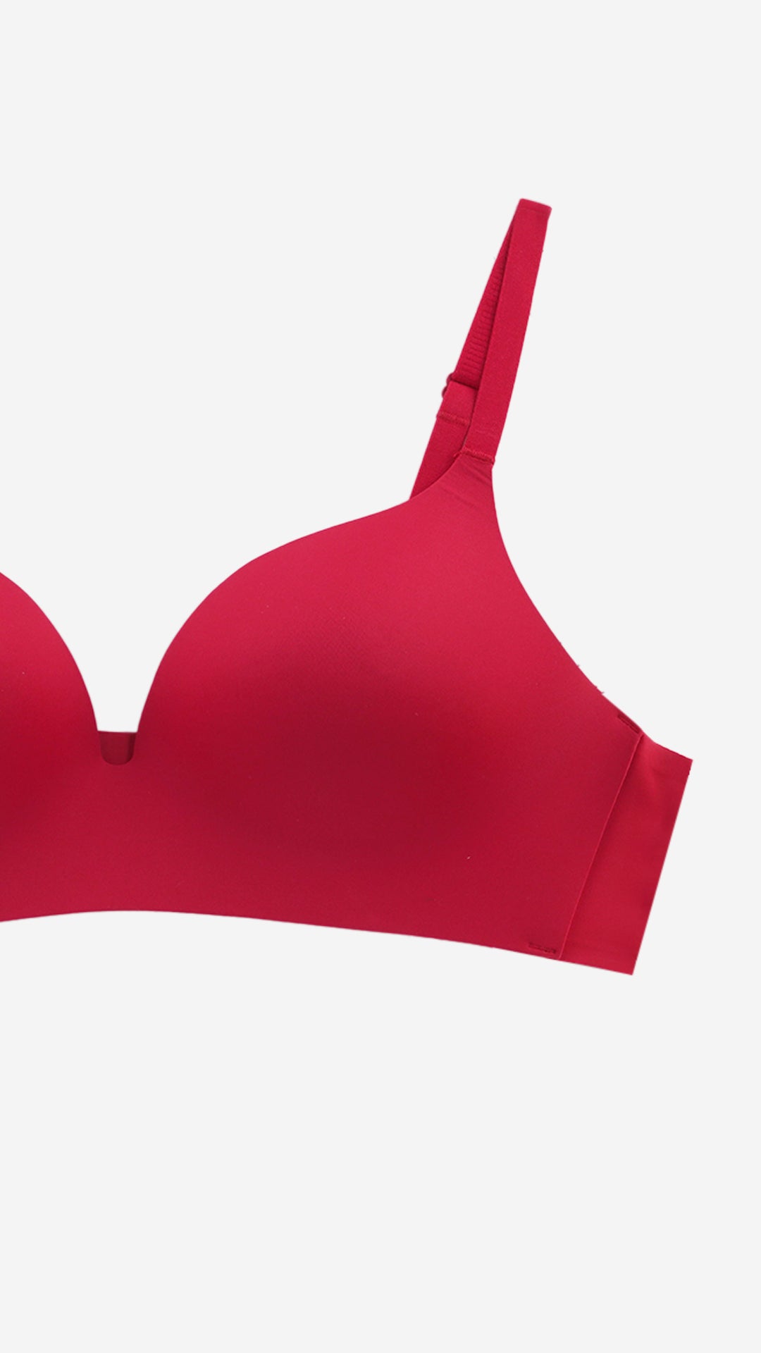Close-up of red seamless T-shirt bra cup and strap on white background