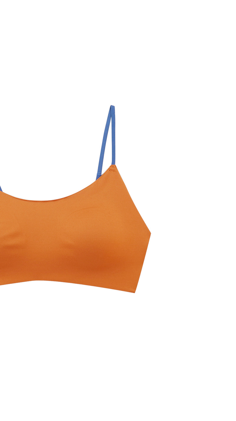 Close-up product shot of orange bralette strap and neckline detail