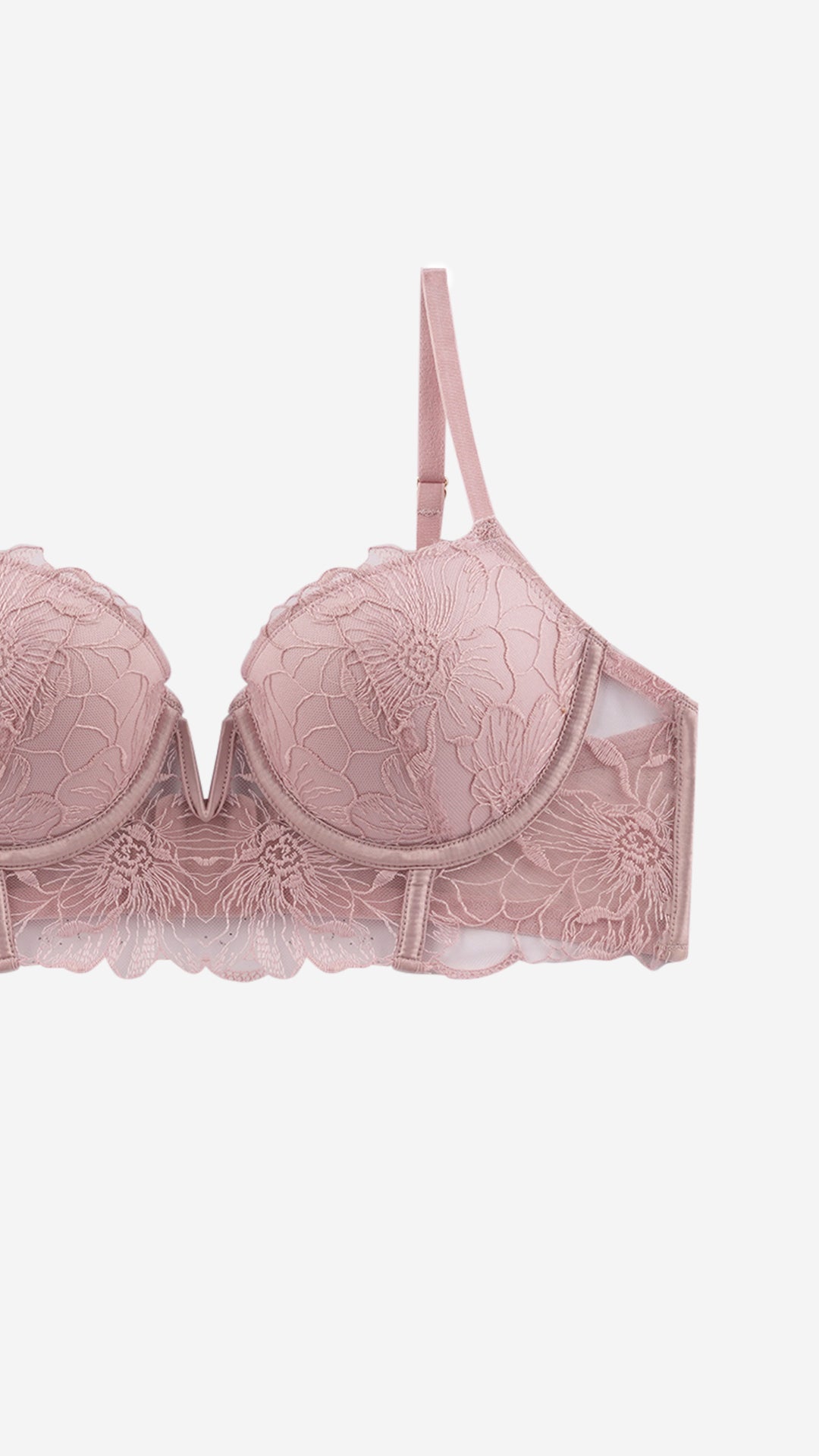 Close-up of pink floral lace balconette bra strap and scalloped cup edge on white background