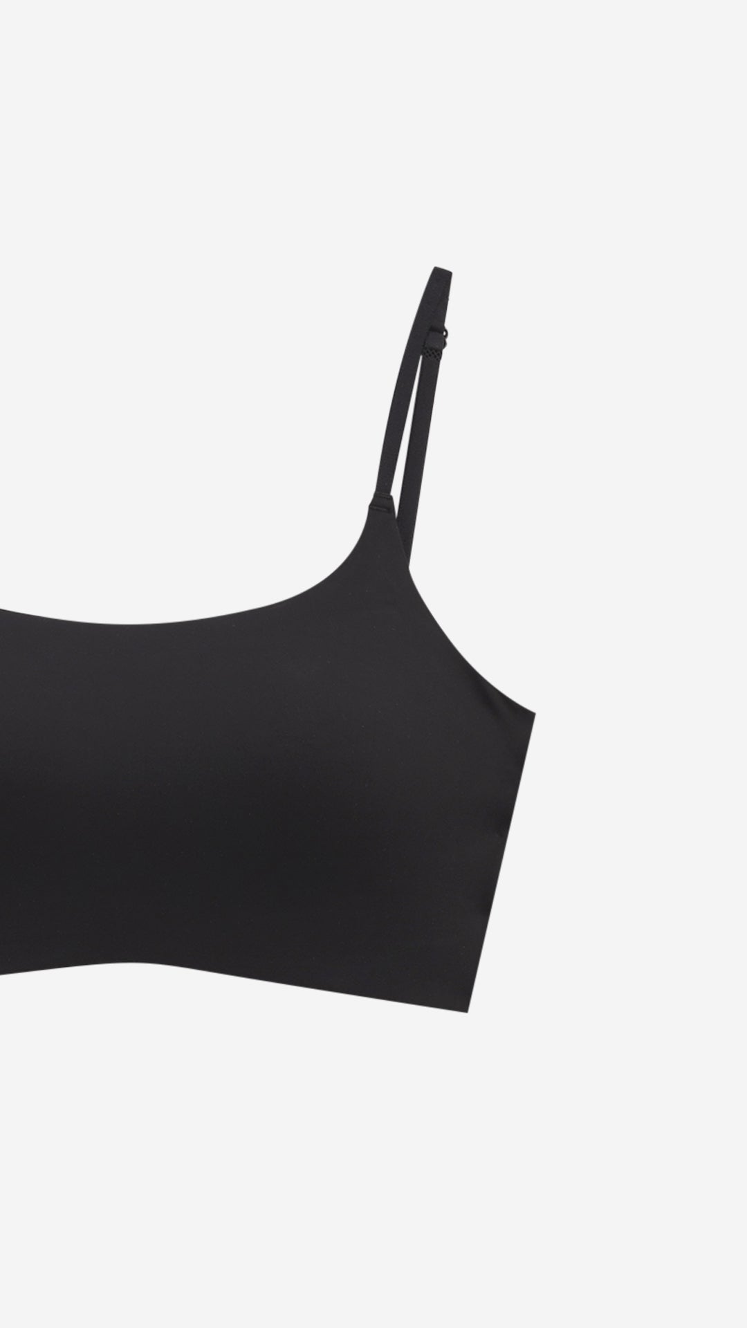 Close-up of black seamless bralette strap and cup edge on white background