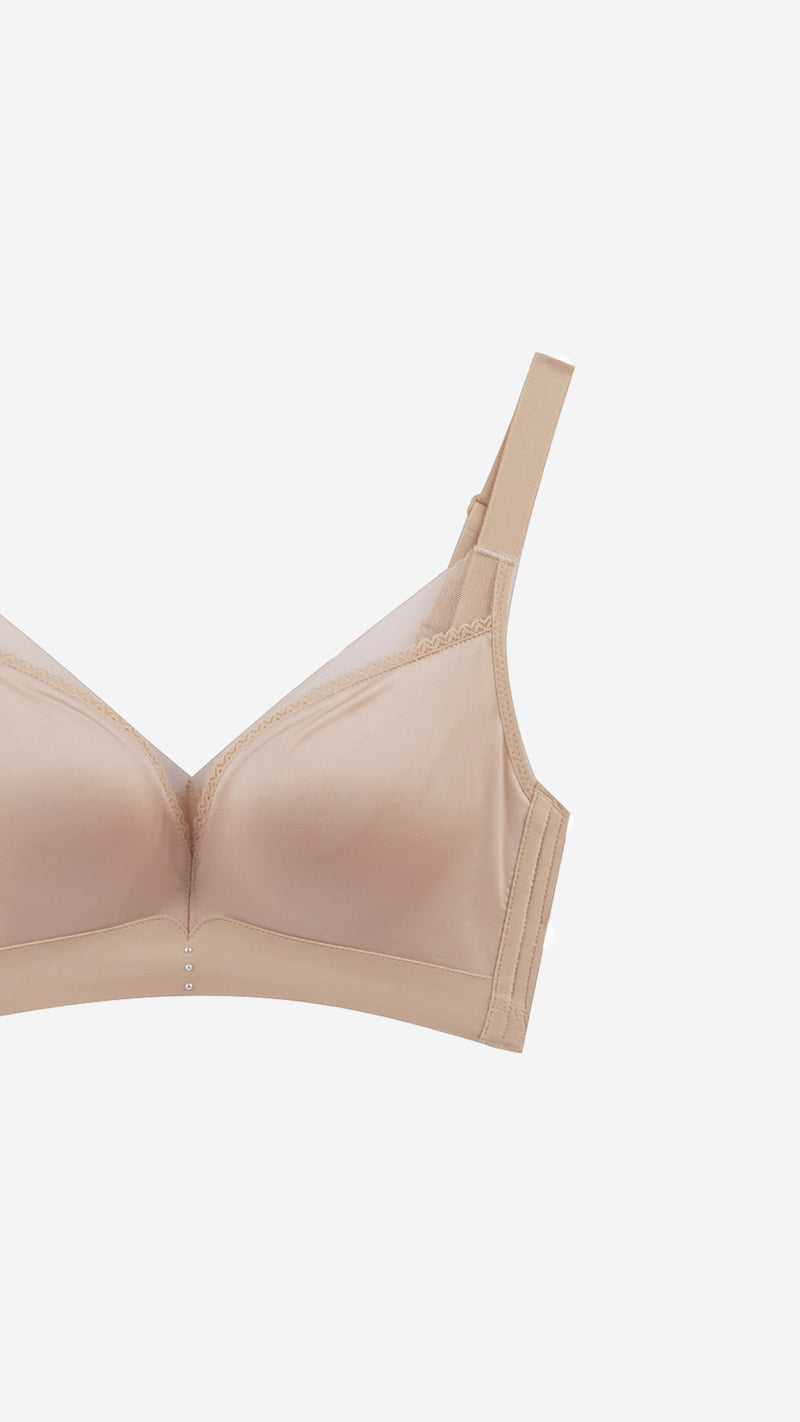 Close-up product shot of beige bra strap and lace trim detail