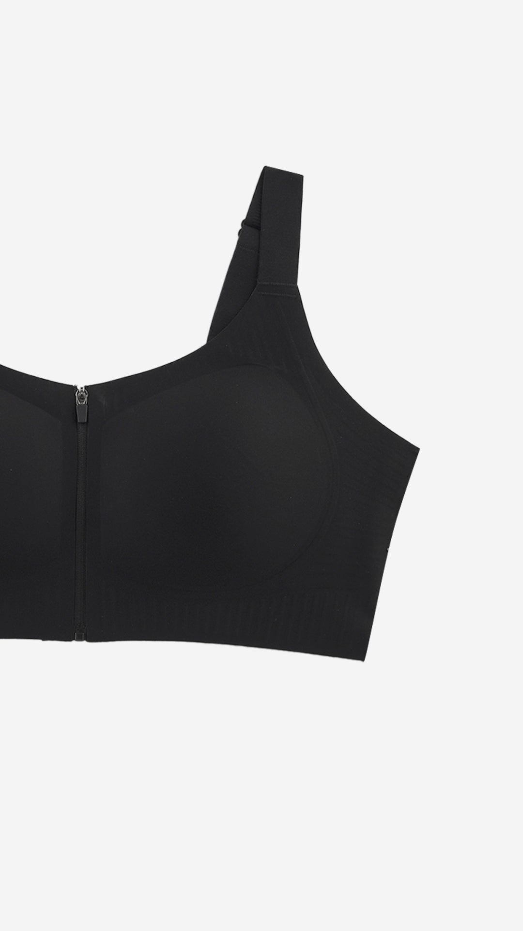 Close-up of black front-zip sports bra strap and cup on white background