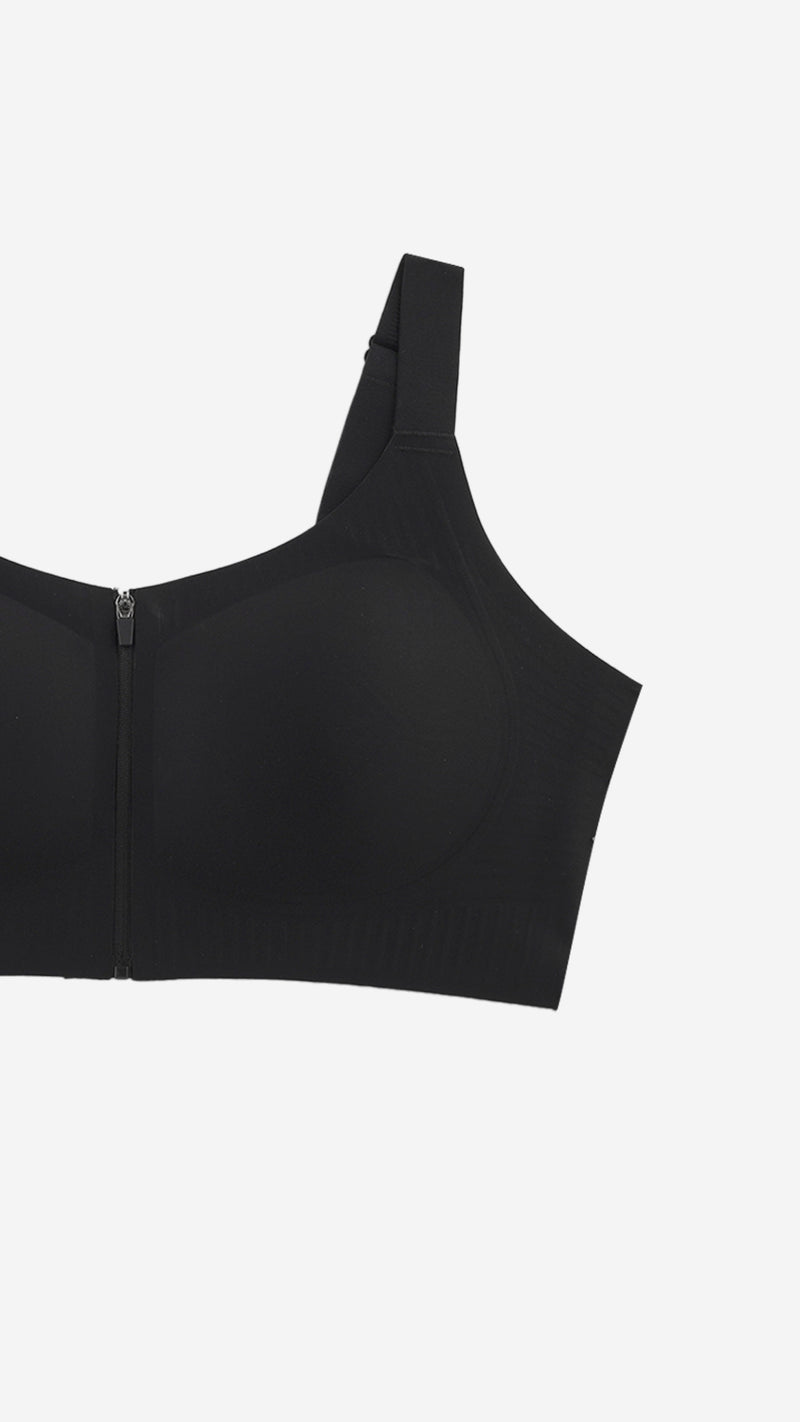 Close-up of black front-zip sports bra strap and cup on white background