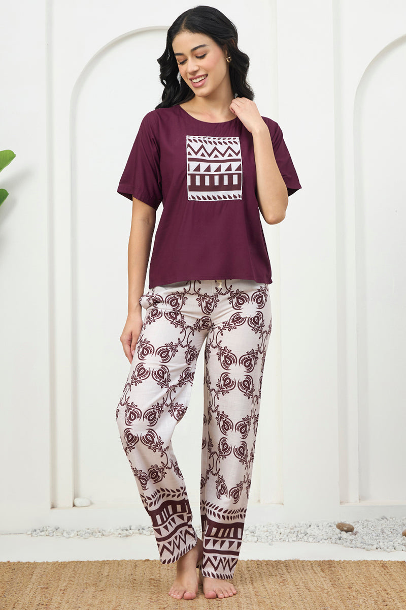 Woman smiling in a wine top with printed pyjama pants