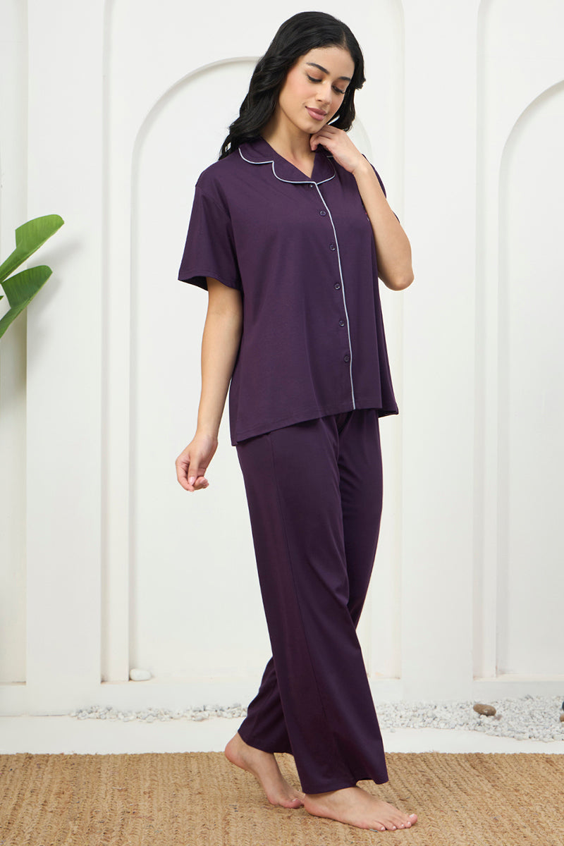 Woman standing in a purple pyjama set with contrast piping