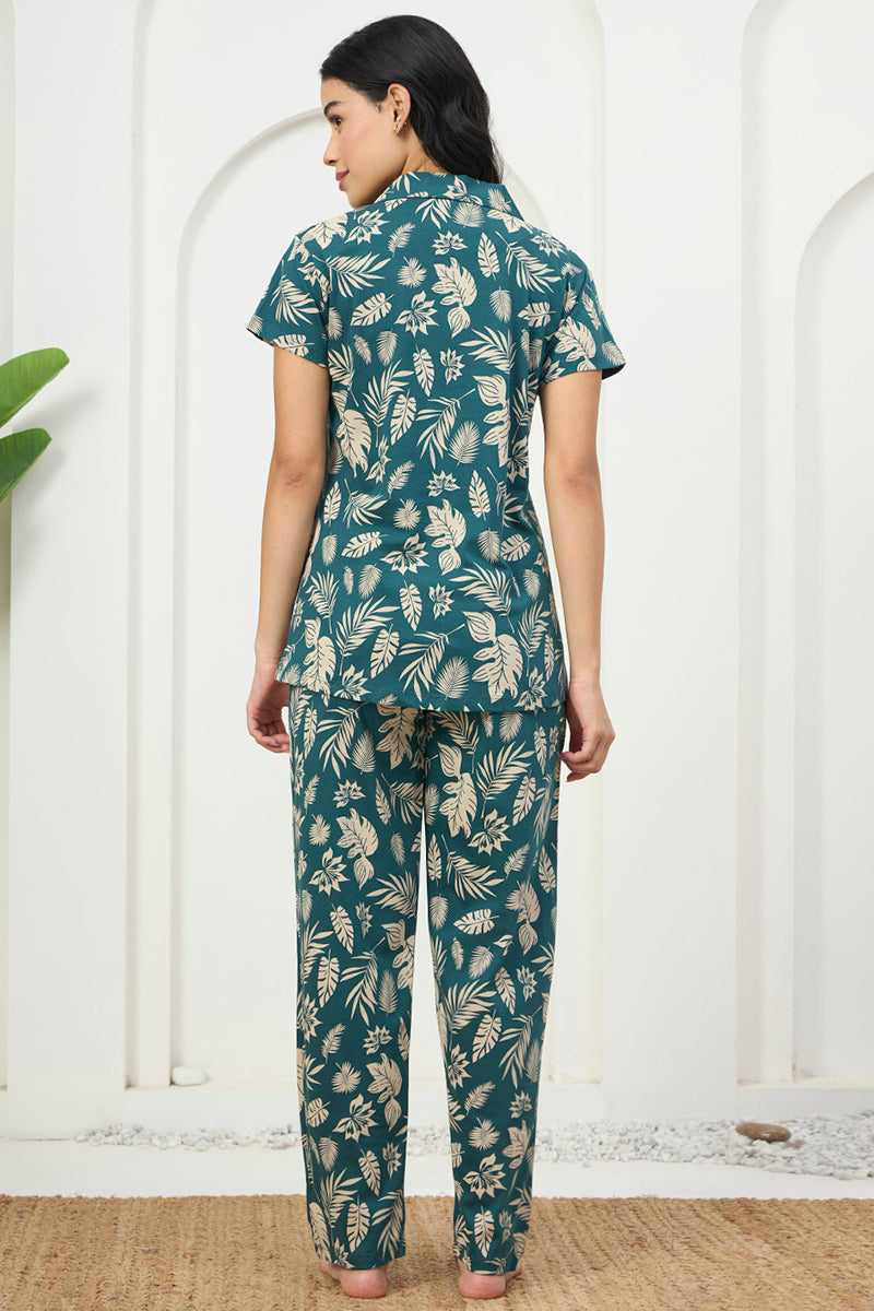 Back view of a woman wearing a teal tropical leaf print shirt and pants