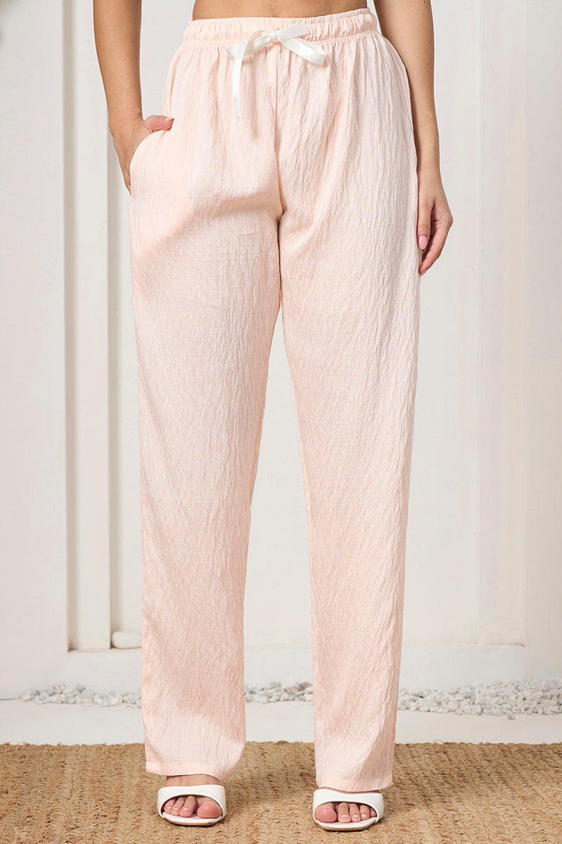Close-up of the peach pants waistband with drawstring tie and side pocket detail