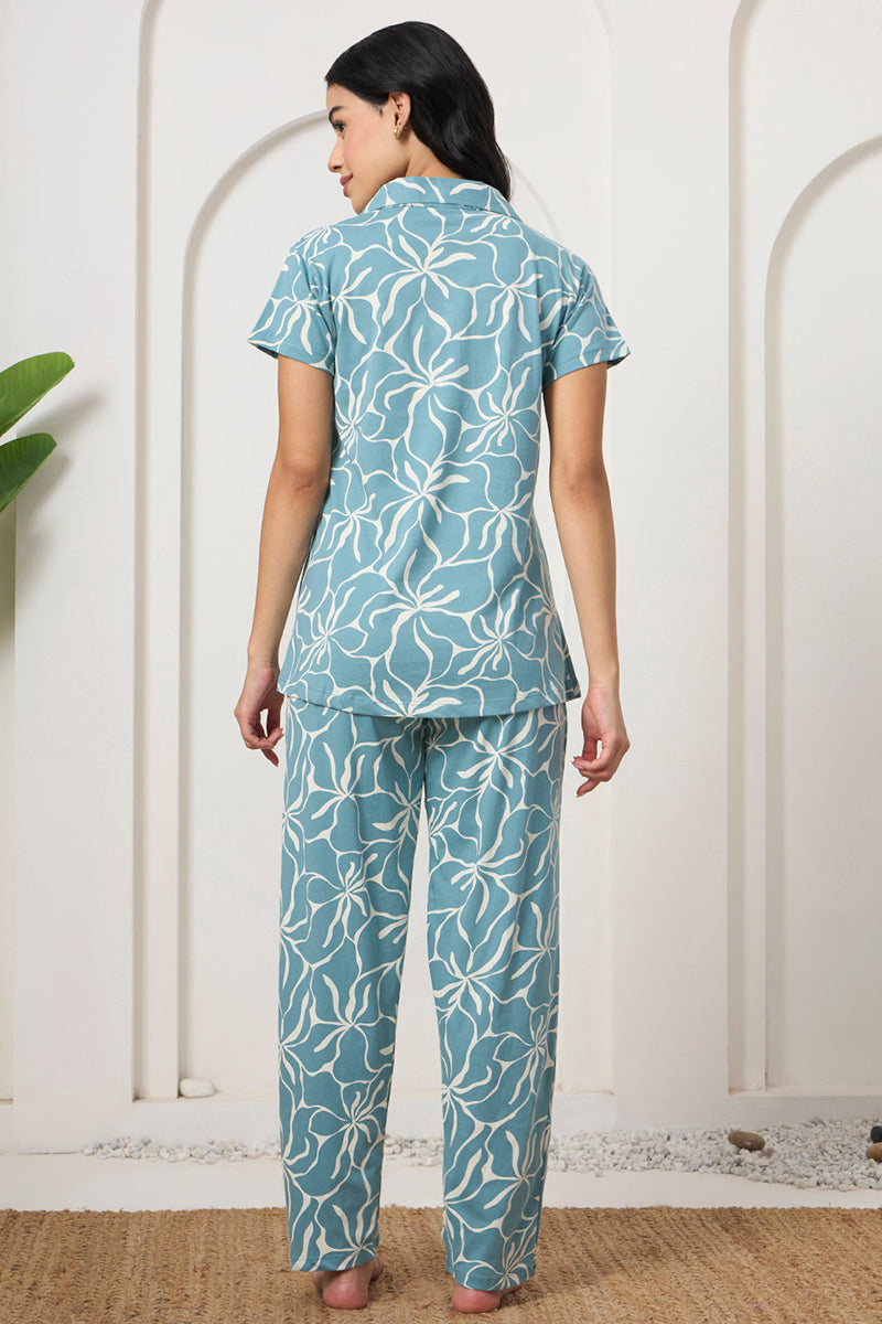 Back view of a woman wearing a dusty blue floral print shirt and pants