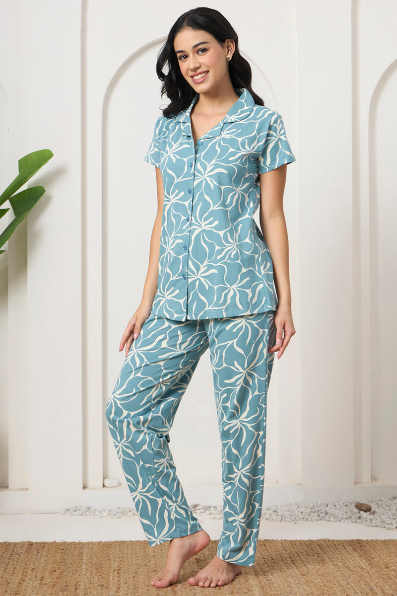 Woman posing in a dusty blue floral print shirt and pants set, front view
