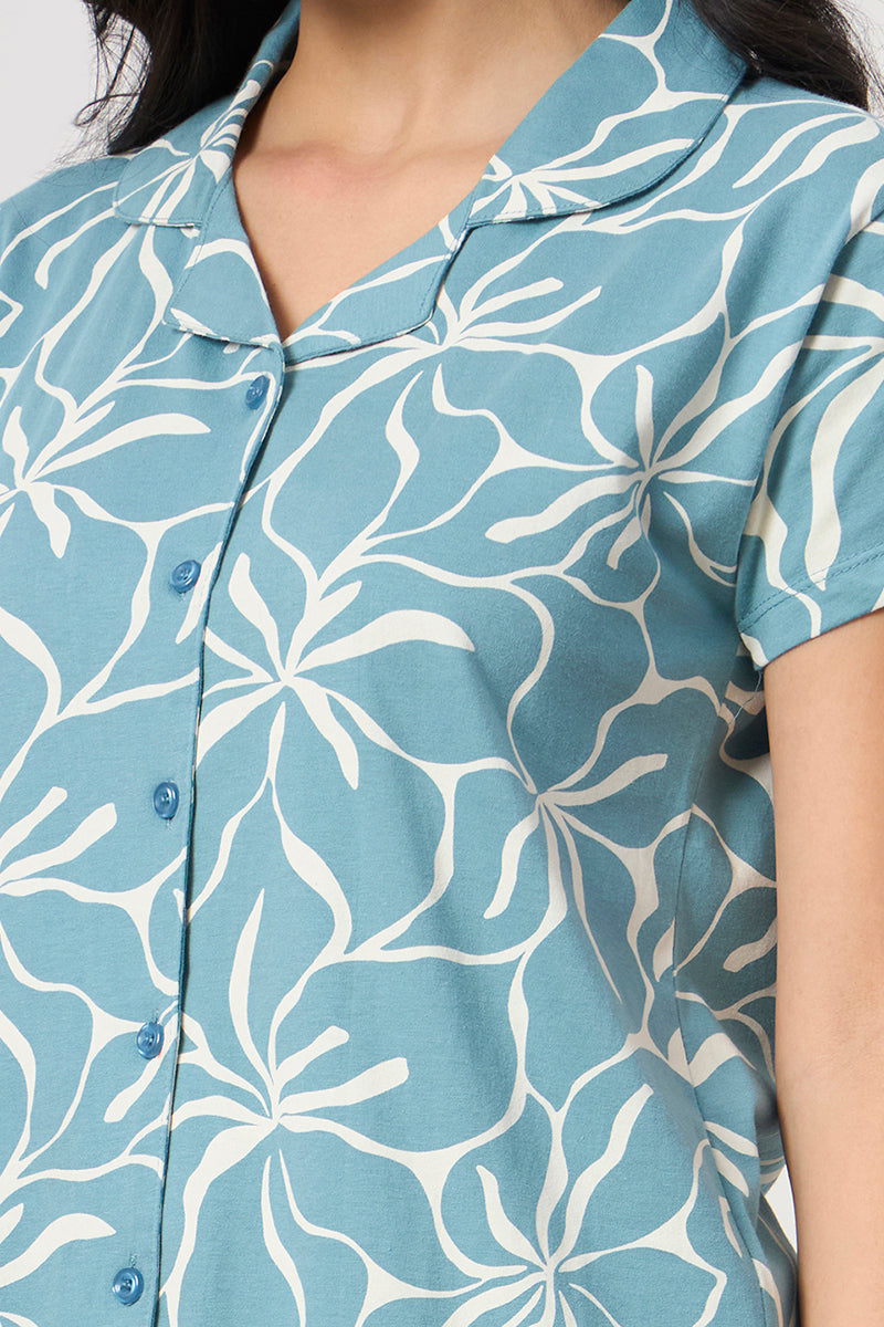 Close up of the notch collar and floral print detail on the dusty blue shirt