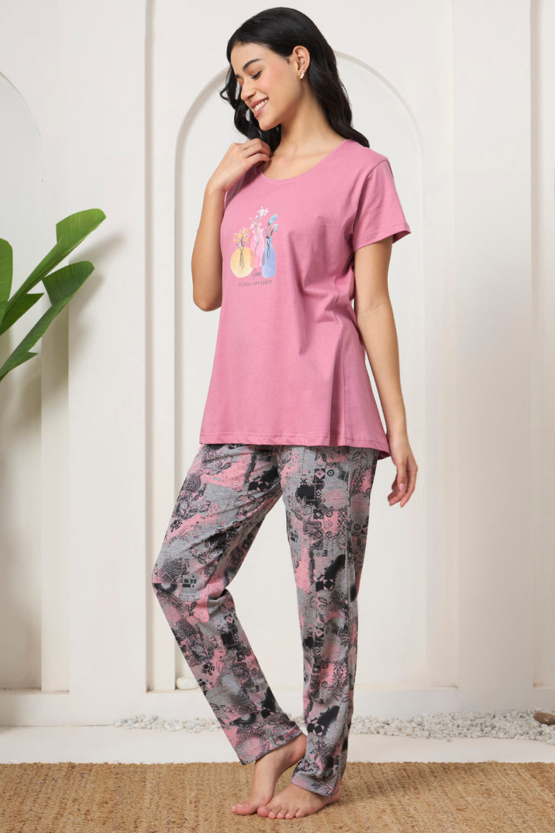 Smiling woman in a pink graphic tee with printed lounge pants