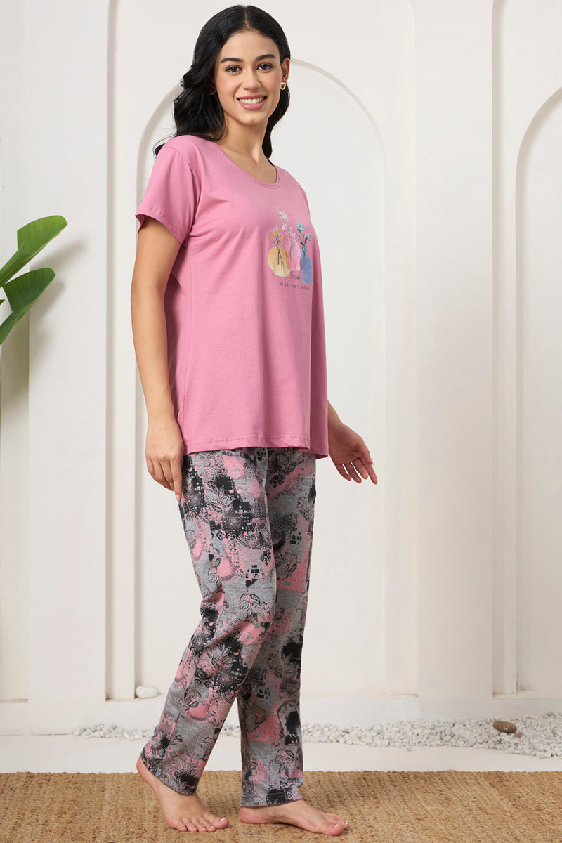 Woman in a pink graphic tee and printed pants, side view