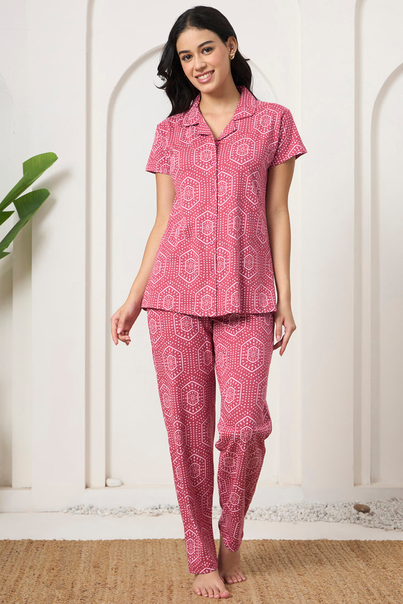 Woman standing in a pink bandhani print shirt and pants set