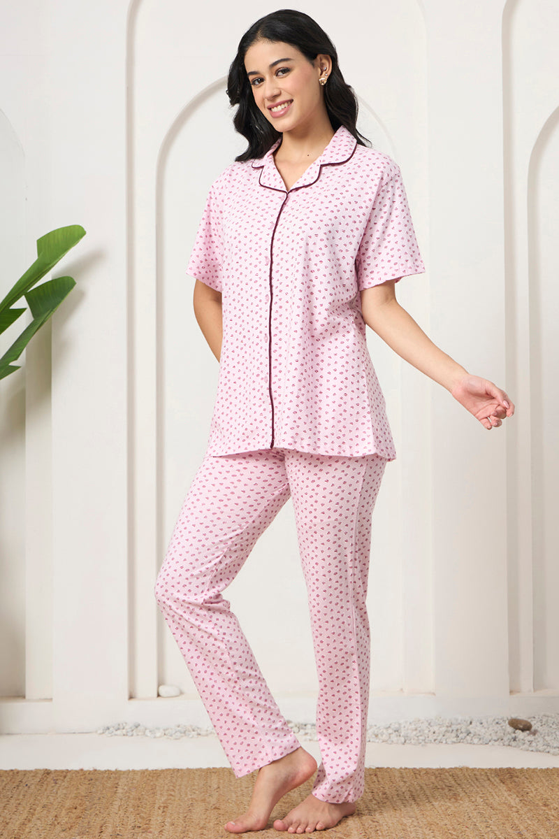 Woman smiling in a pink printed shirt and pants set, front view