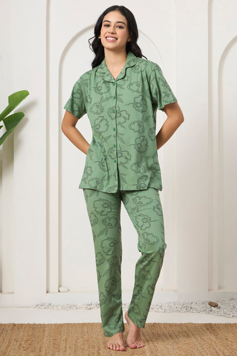 Woman standing in a sage green floral print shirt and pants set