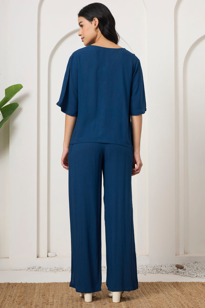 Back view of a woman wearing a teal shirt and wide leg pants