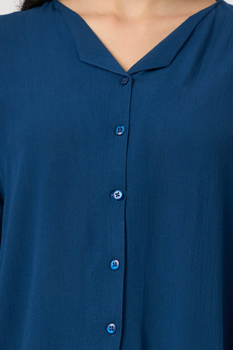Close up of the collar and button placket on the teal shirt