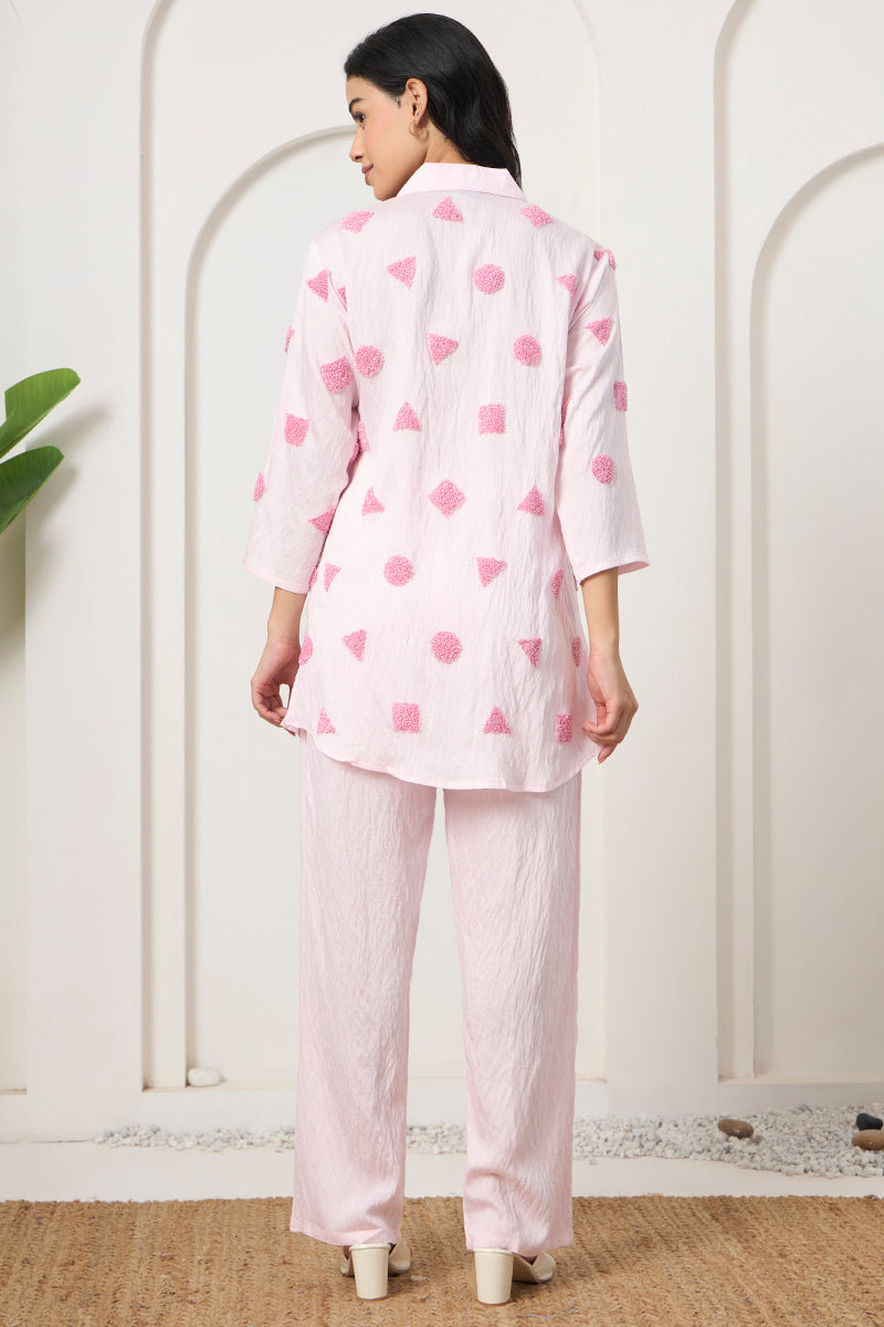 Back view of the pink tunic and pant set showing the textured motif placement across the back