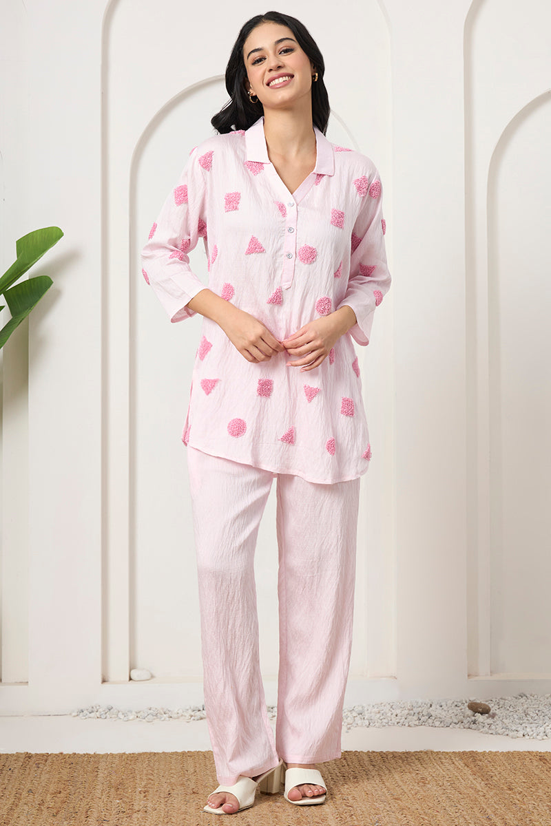Woman smiling in a pink embroidered tunic co-ord set with textured motifs and matching wide-leg pants