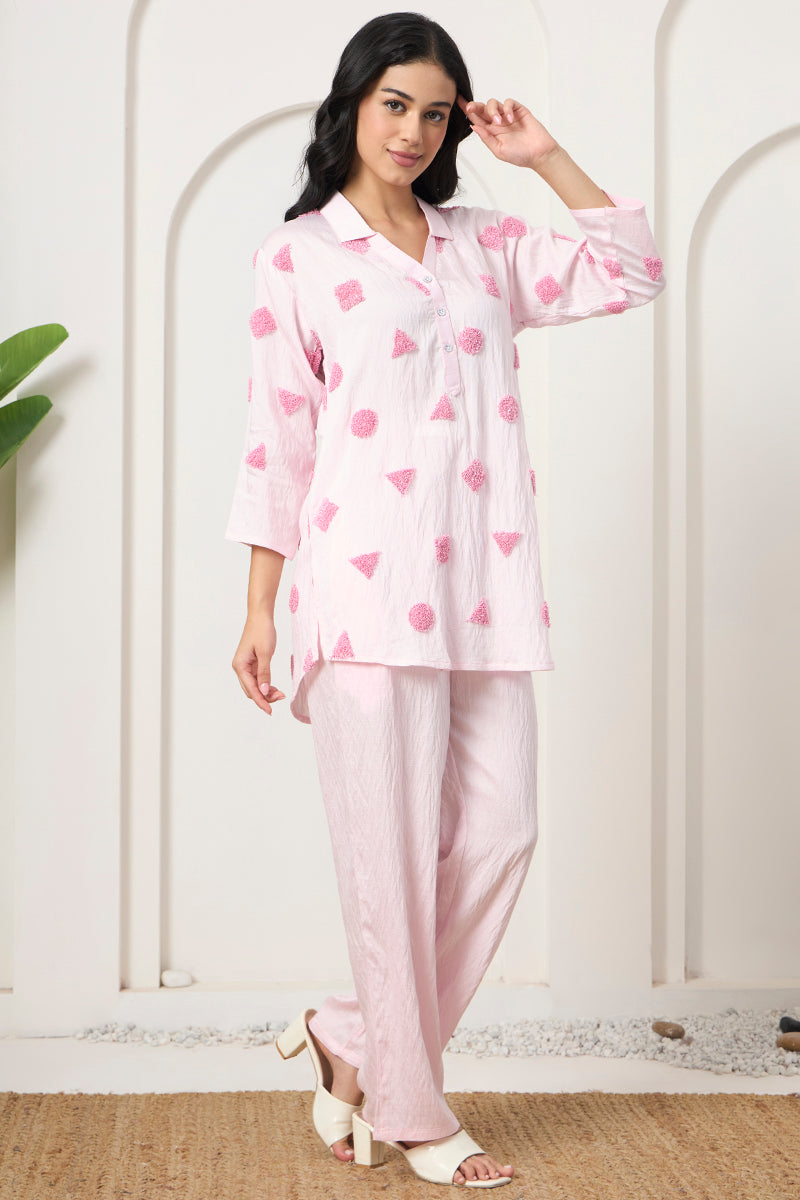 Close-up front pose in a pink embroidered tunic and matching pants set with block heel sandals