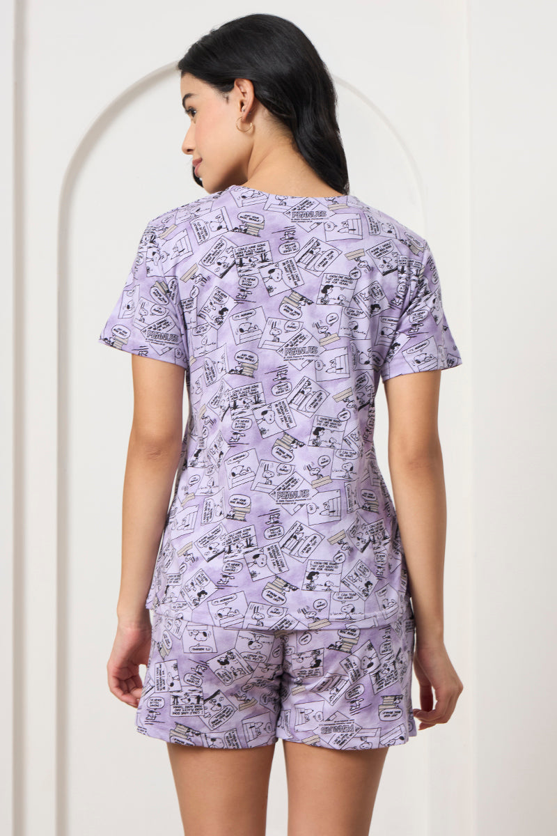 Back view of a woman wearing a lilac comic print t-shirt and shorts