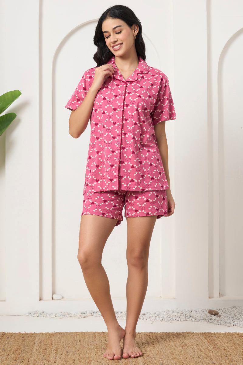 Woman standing in a pink heart print shirt and shorts set