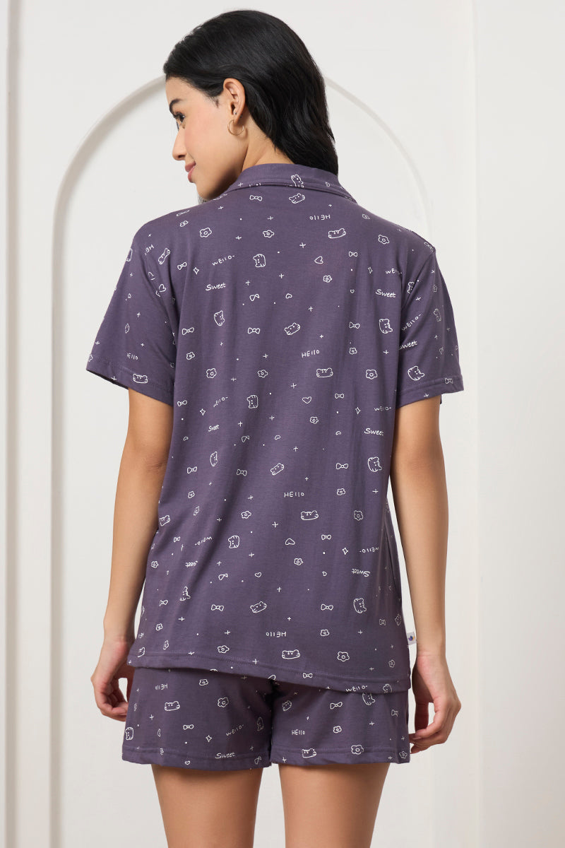 Back view of a woman wearing a grey printed shirt and shorts