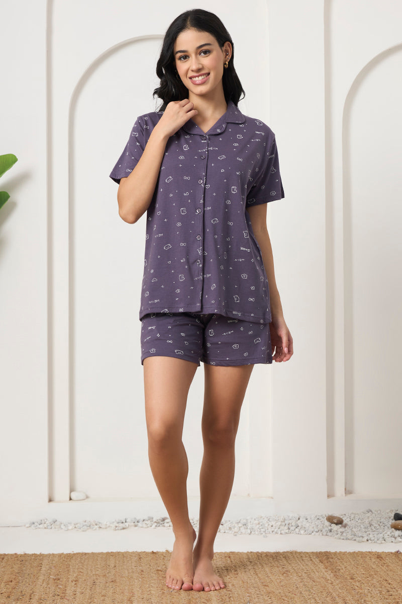 Woman standing in a grey printed shirt and shorts set