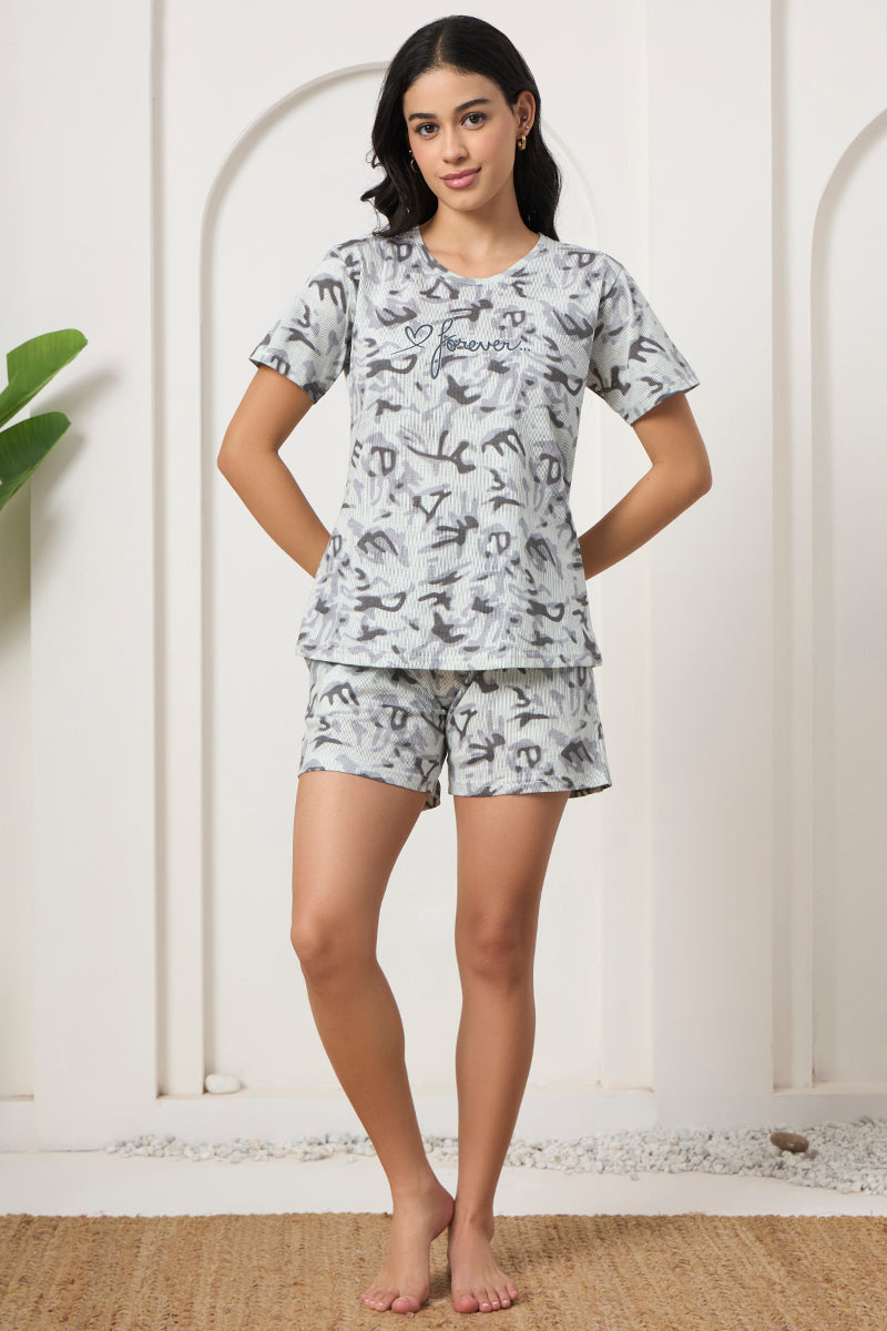 Woman standing in a grey abstract print t-shirt and shorts set