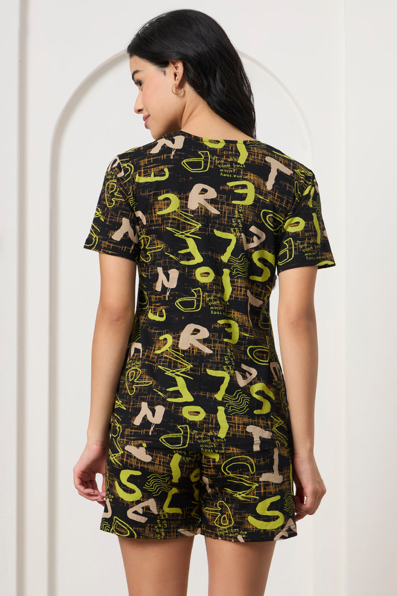 Back view of a woman wearing a black graphic print t-shirt and shorts
