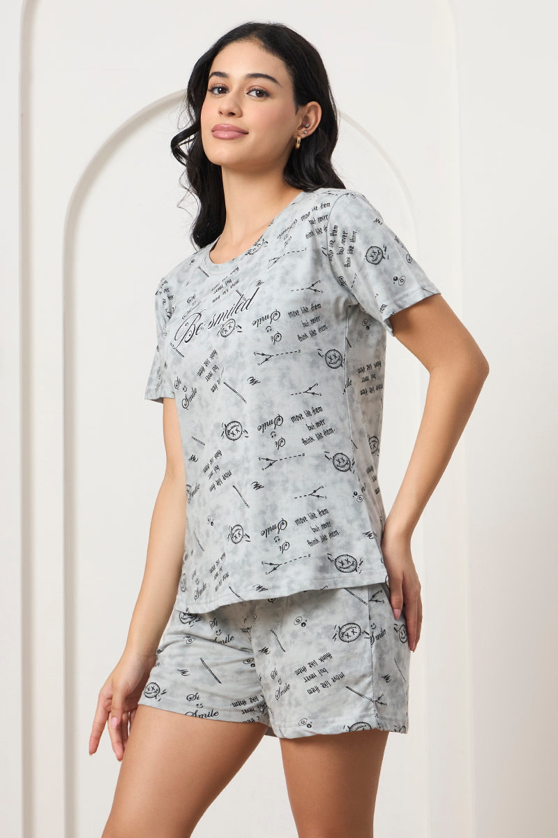 Woman standing sideways in a grey printed t-shirt and shorts set